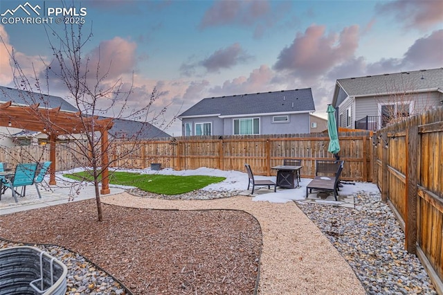 yard at dusk featuring an outdoor fire pit, a pergola, and a patio area