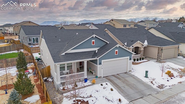 ranch-style home with a garage, a mountain view, and covered porch