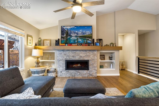 living room featuring ceiling fan, a fireplace, vaulted ceiling, and light hardwood / wood-style flooring