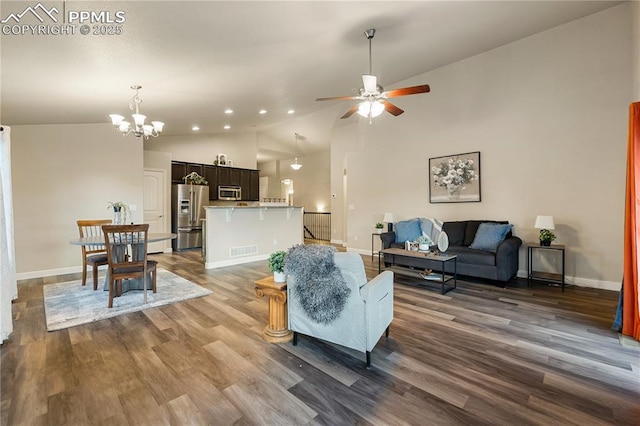 living room with lofted ceiling, dark wood-type flooring, and ceiling fan with notable chandelier