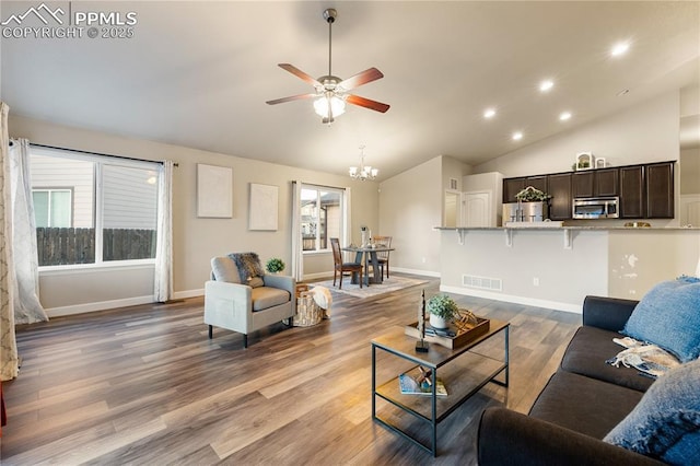 living room with hardwood / wood-style flooring, high vaulted ceiling, and ceiling fan with notable chandelier