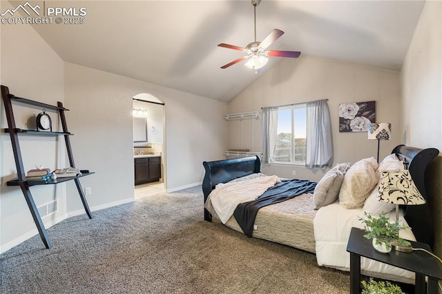 bedroom with light carpet, ensuite bath, vaulted ceiling, and ceiling fan