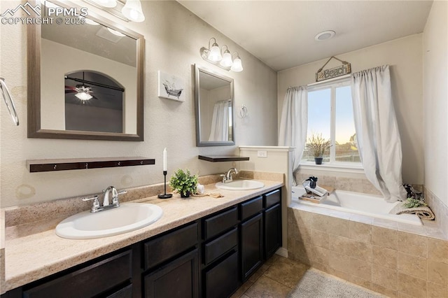 bathroom featuring tile patterned floors, vanity, and tiled bath