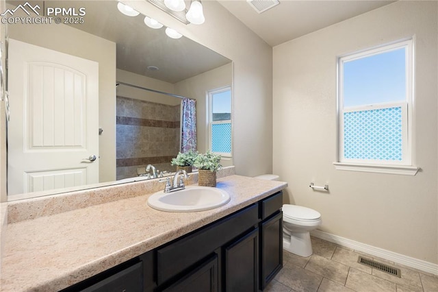 bathroom with vanity, curtained shower, a wealth of natural light, and toilet