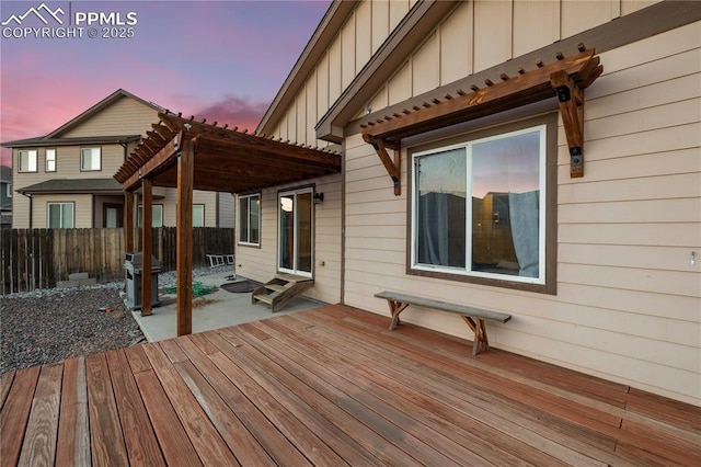 deck at dusk featuring a pergola, grilling area, and a patio