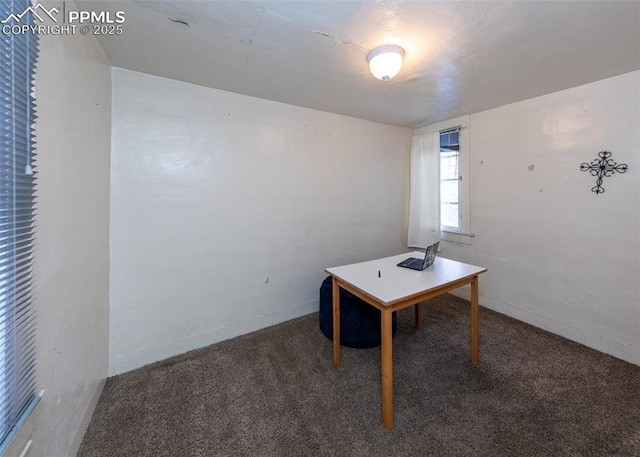 unfurnished office featuring dark carpet