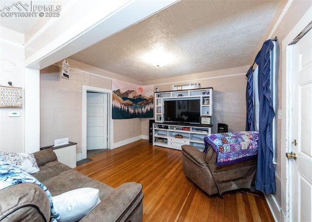 living room with wood-type flooring and a textured ceiling