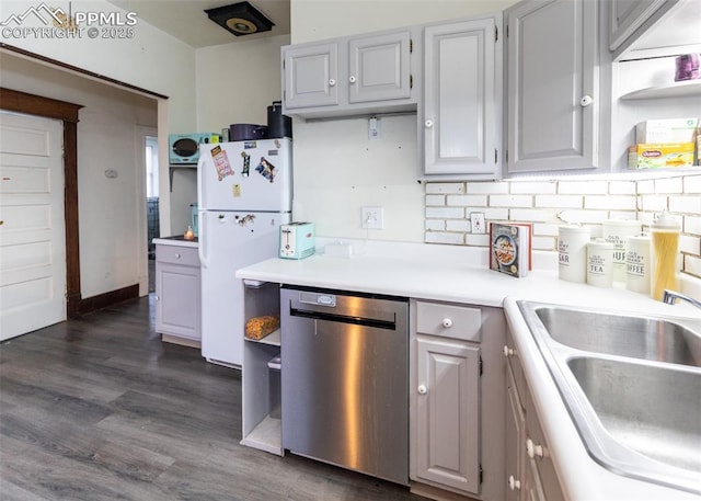 kitchen with sink, dark hardwood / wood-style flooring, decorative backsplash, white fridge, and stainless steel dishwasher