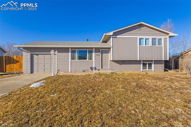 split level home with a garage and a front yard