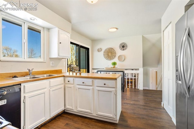 kitchen featuring dark hardwood / wood-style floors, dishwasher, sink, stainless steel fridge, and white cabinets