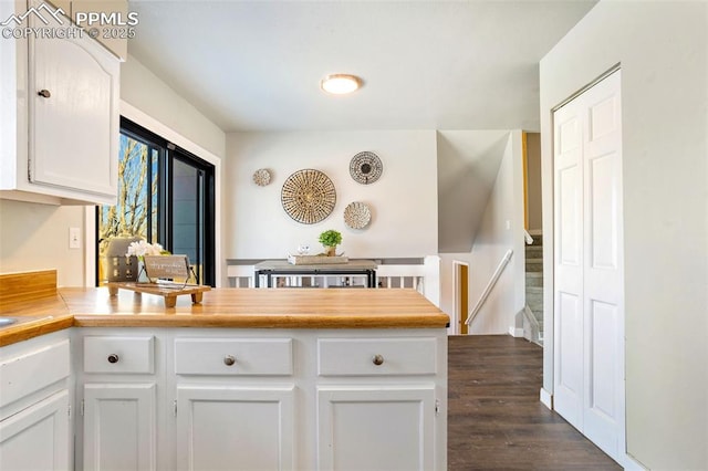 kitchen with dark hardwood / wood-style floors and white cabinets