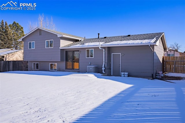 snow covered back of property featuring cooling unit