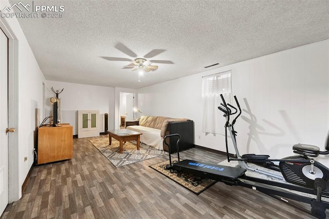 workout room featuring ceiling fan, hardwood / wood-style floors, and a textured ceiling