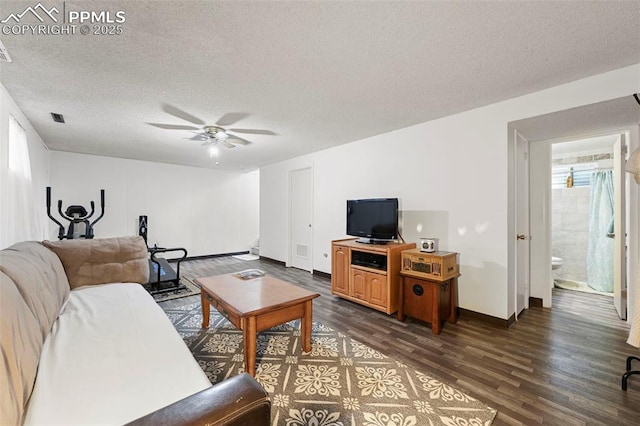 living room with ceiling fan, dark hardwood / wood-style floors, and a textured ceiling