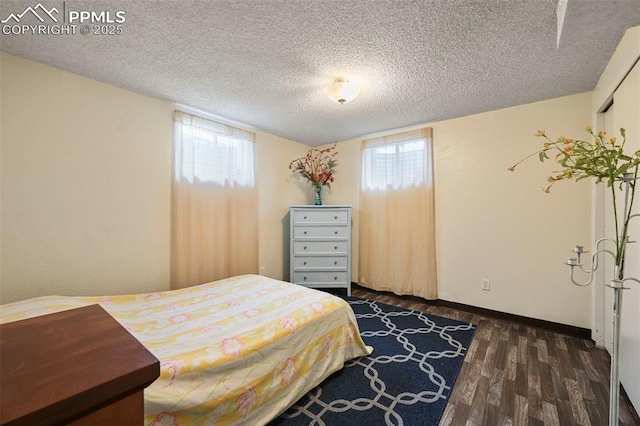 bedroom featuring dark wood-type flooring and a textured ceiling