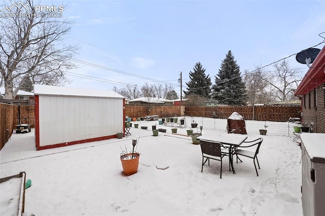 yard covered in snow with a storage unit