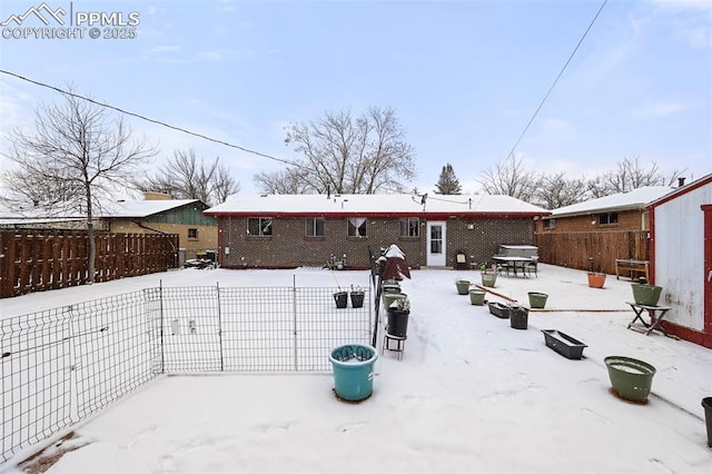 view of snow covered back of property