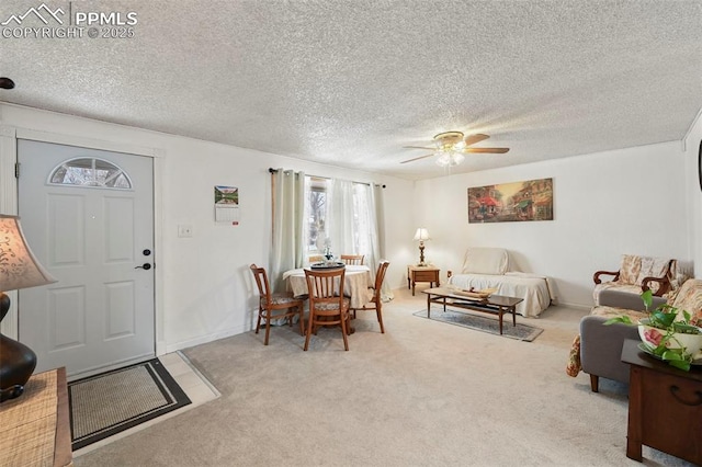 carpeted living room featuring a textured ceiling and ceiling fan