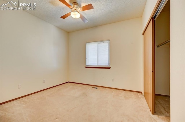 unfurnished bedroom featuring light carpet, a closet, and a textured ceiling