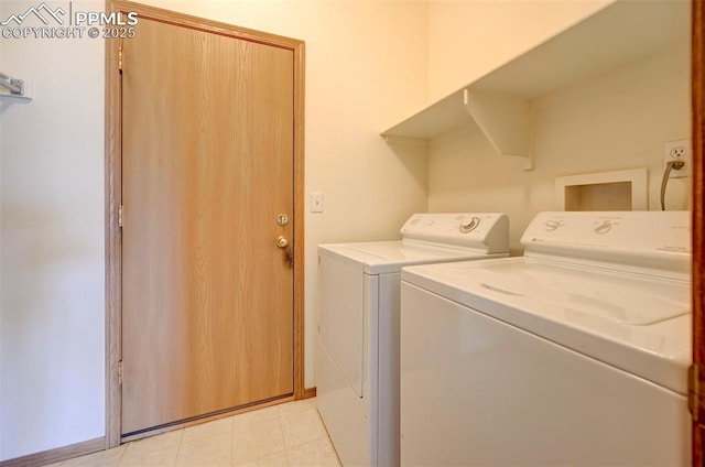 laundry room with independent washer and dryer and light tile patterned flooring