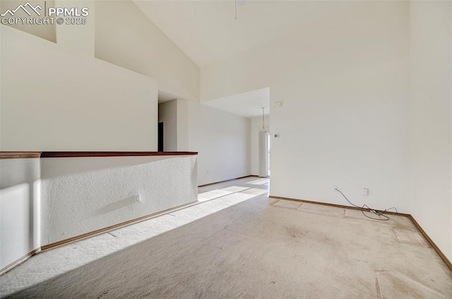 empty room with carpet floors and high vaulted ceiling