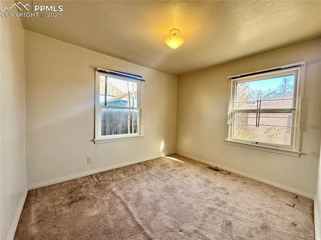 carpeted empty room featuring a textured ceiling