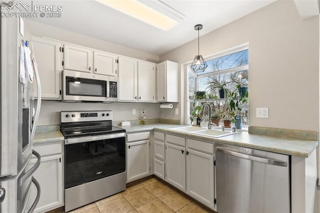 kitchen with stainless steel appliances, white cabinetry, hanging light fixtures, and sink