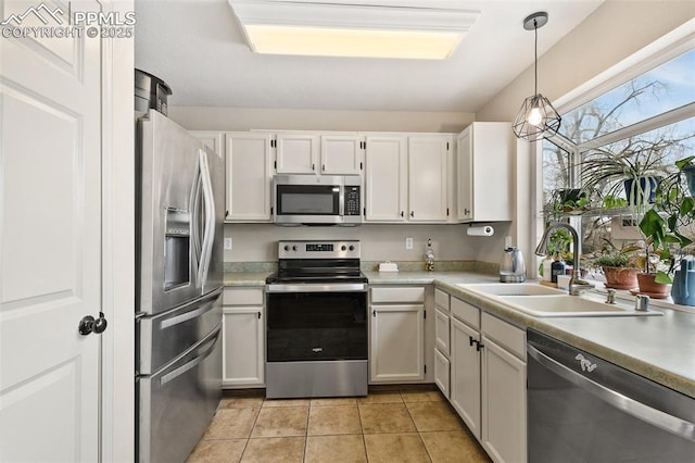 kitchen with appliances with stainless steel finishes, hanging light fixtures, and white cabinets