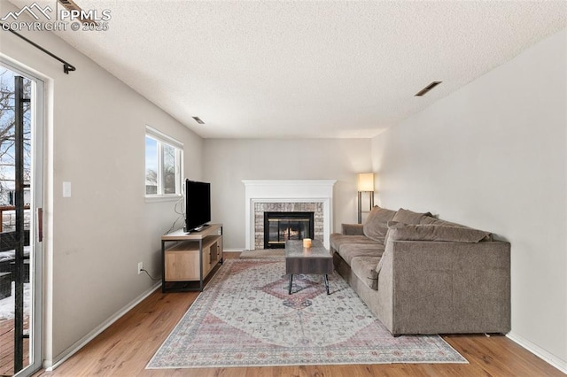 living room with a textured ceiling and light hardwood / wood-style floors