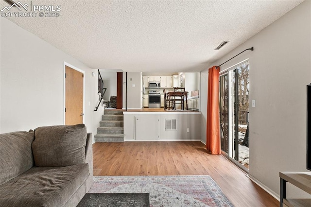 living room with light hardwood / wood-style flooring and a textured ceiling