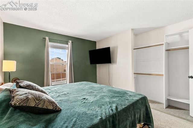 carpeted bedroom with a closet and a textured ceiling