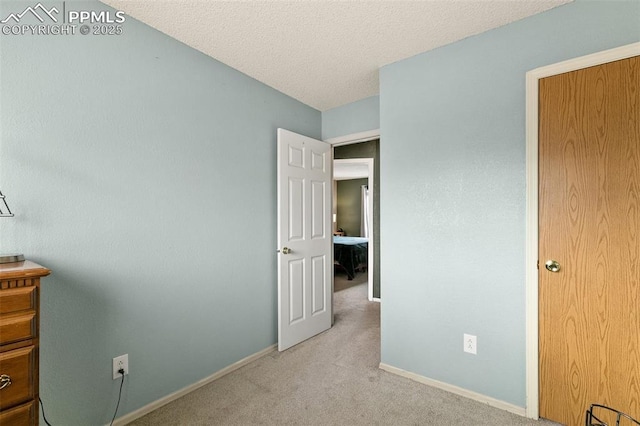 unfurnished bedroom with light colored carpet and a textured ceiling