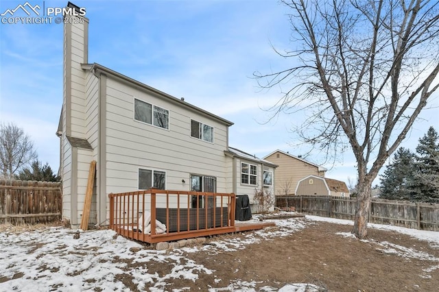 snow covered house with a wooden deck