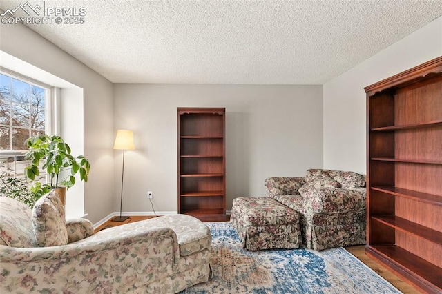 living area with hardwood / wood-style floors and a textured ceiling