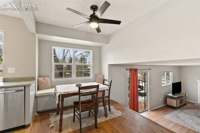 dining space with ceiling fan, a textured ceiling, and light hardwood / wood-style floors