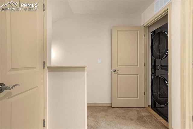 laundry area with light colored carpet and stacked washing maching and dryer