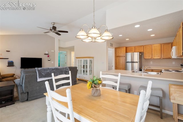 dining area with ceiling fan with notable chandelier, lofted ceiling, sink, and light carpet