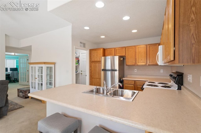 kitchen featuring range with electric cooktop, stainless steel fridge, and kitchen peninsula