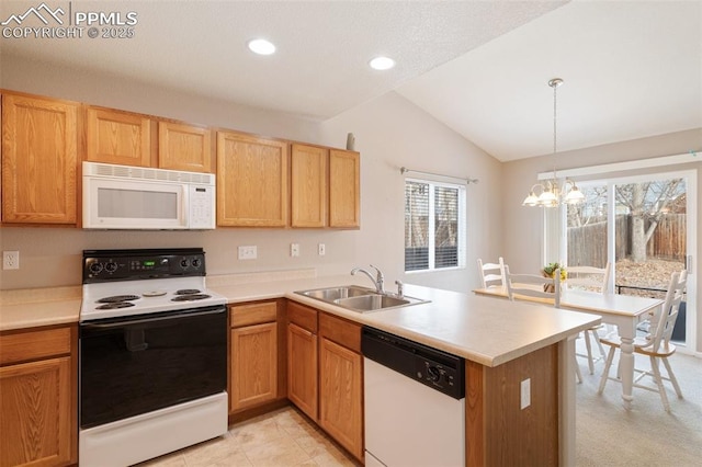 kitchen with pendant lighting, sink, white appliances, vaulted ceiling, and kitchen peninsula