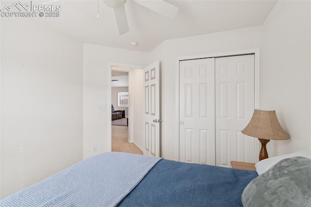 carpeted bedroom featuring ceiling fan and a closet