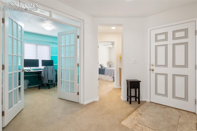 entrance foyer featuring light carpet, french doors, and ceiling fan