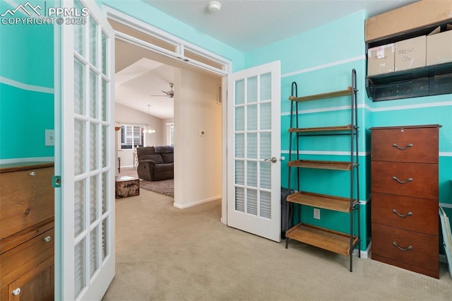 interior space featuring lofted ceiling, light colored carpet, french doors, and ceiling fan