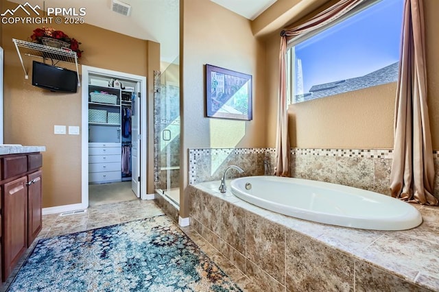 bathroom featuring vanity and separate shower and tub