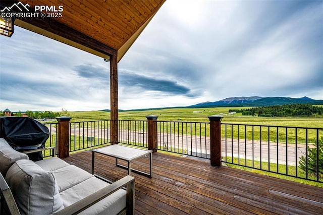 deck featuring a grill, a mountain view, and a rural view