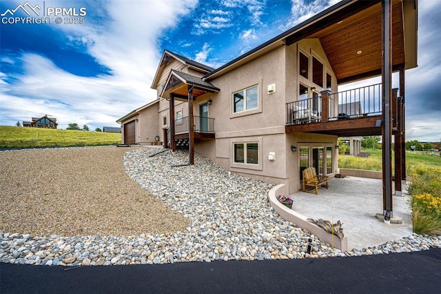 view of home's exterior featuring a balcony and a patio