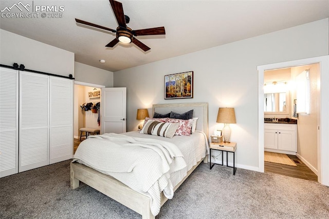 carpeted bedroom featuring ceiling fan, ensuite bathroom, and a closet