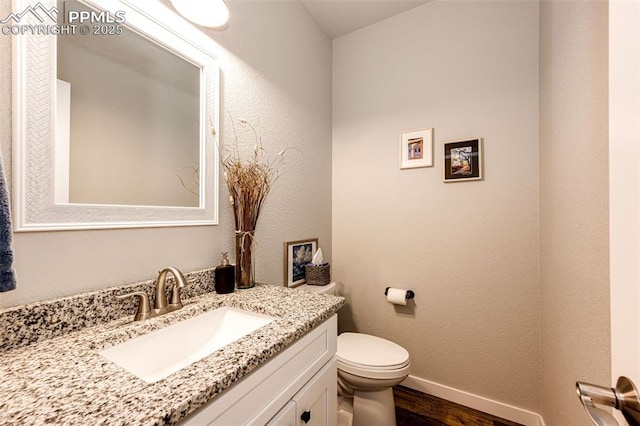 bathroom with vanity, hardwood / wood-style floors, and toilet