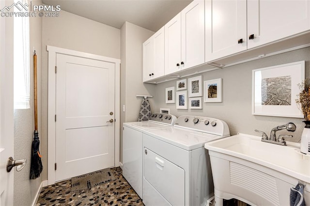 laundry area featuring cabinets, sink, and washer and dryer