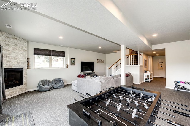 rec room with a stone fireplace and carpet floors