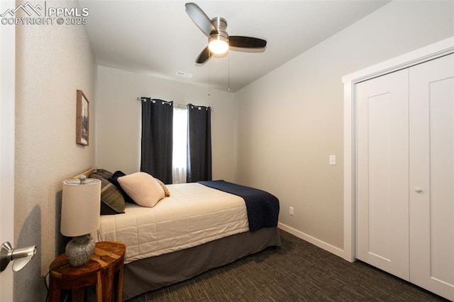 bedroom with dark carpet, ceiling fan, and a closet